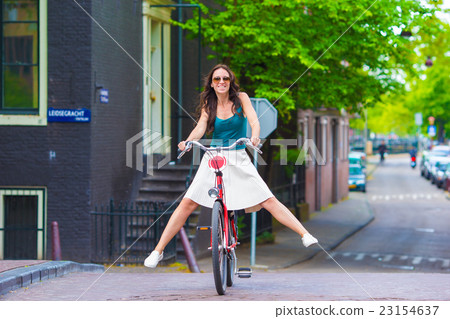 Young happy woman on bike in european city Young happy woman on bike in european city 23154637
