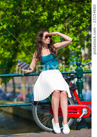 Young beautiful woman on bike in european city Young beautiful woman on bike in european city 23154660
