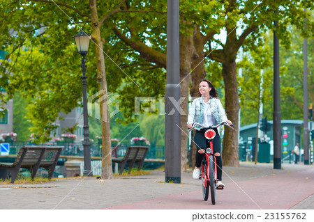 Young happy woman on bike in european city Young happy woman on bike in european city 23155762