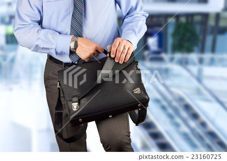 Businessman holding and opening a briefcase 23160725