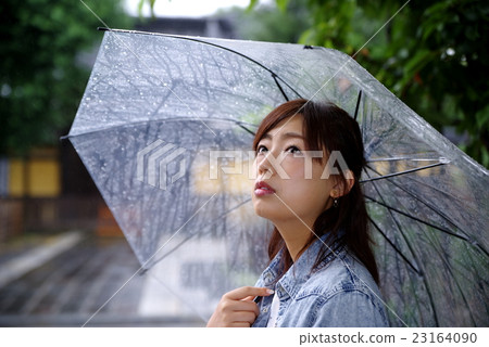 一個女人把一把雨傘的日本外觀在門前的日本石頭路面 23164090