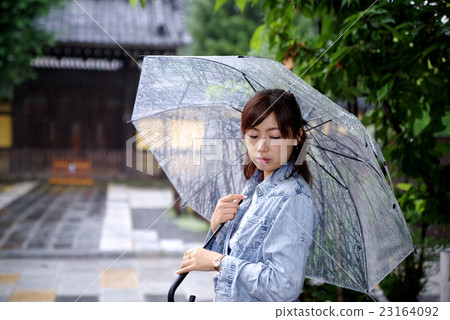 一個女人把一把雨傘的日本外觀在門前的日本石頭路面 23164092