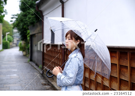 A woman putting out an umbrella Japanese appearance of the rainy season White walls, boards and cobblestones A woman putting out an umbrella Japanese appearance of the rainy season White walls, boards and cobblestones 23164512
