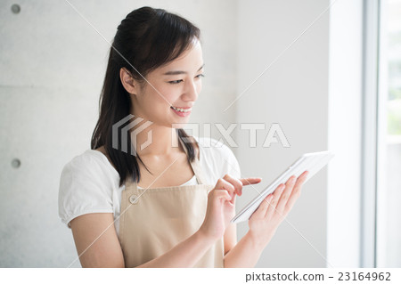 A woman using a tablet PC A woman using a tablet PC 23164962