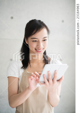 A woman using a tablet PC A woman using a tablet PC 23164963