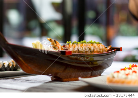 Sushi boat with cooked shrimp. 23175444