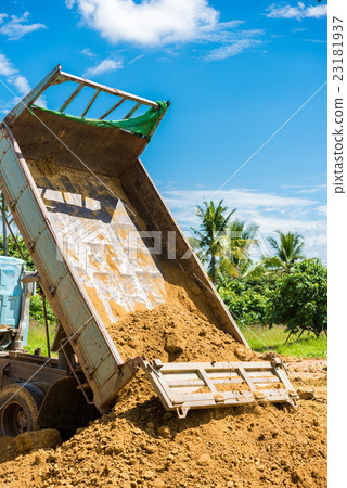 Dump truck unloading soil at construction site Dump truck unloading soil at construction site 23181937