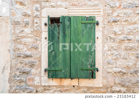 Green wooden door on brick wall 23183412