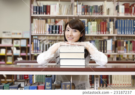 A woman choosing a book in a library 23187237