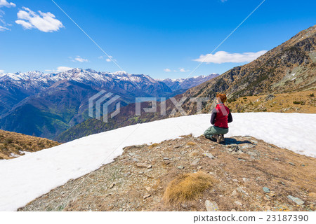 Hiker kneeling and resting on the scenic mountain summit Hiker kneeling and resting on the scenic mountain summit 23187390