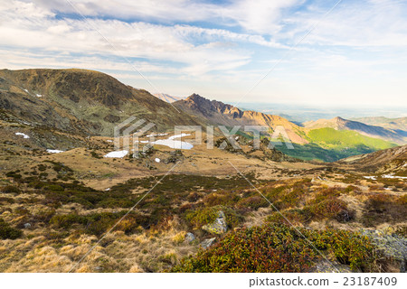 Last soft sunlight over rocky mountain peaks 23187409
