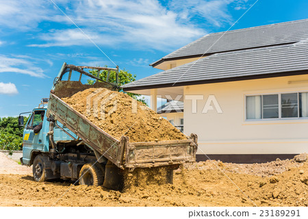 Dump truck unloading soil at construction site Dump truck unloading soil at construction site 23189291