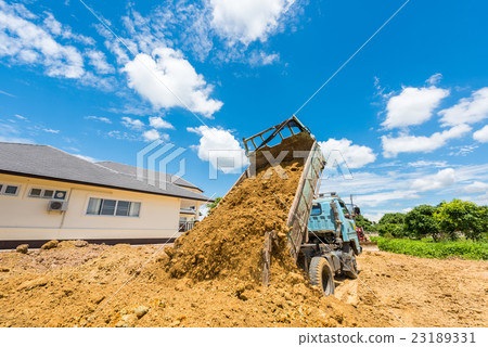 Dump truck unloading soil at construction site Dump truck unloading soil at construction site 23189331