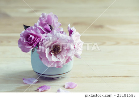 Pink roses in a vase on the table. 23191583