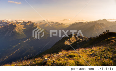 Warm light at sunset on mountain peaks, ridges and valleys Warm light at sunset on mountain peaks, ridges and valleys 23191714