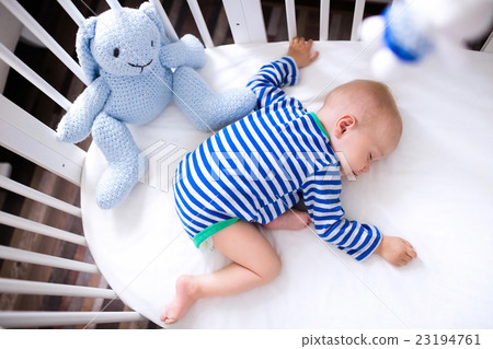Sleeping baby boy in white crib 23194761