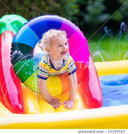 Little boy playing in garden swimming pool Little boy playing in garden swimming pool 23195587