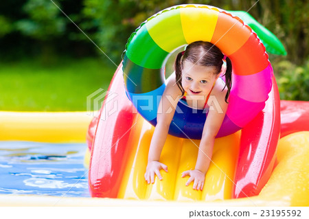 Little girl in garden swimming pool Little girl in garden swimming pool 23195592