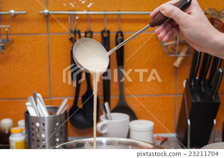 The young woman makes pancakes The young woman makes pancakes 23211704
