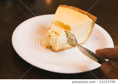 Piece of Cheesecake on white plate in coffee shop Piece of Cheesecake on white plate in coffee shop 23223789