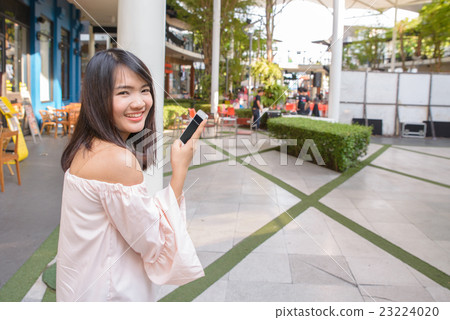 Woman texts message to mobile phone. Woman texts message to mobile phone. 23224020