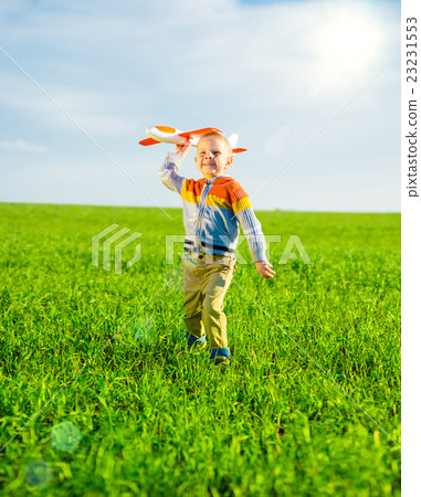 Happy boy playing with toy airplane against blue 23231553
