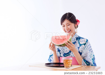 A woman in a yukata eating watermelon 23231883