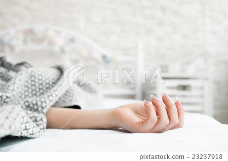 Hand of sleeping in bed covered woman closeup 23237918