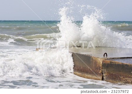 Sea waves breaking on the concrete pier 23237972