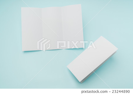 Trifold white template paper on blue background . Trifold white template paper on blue background . 23244890