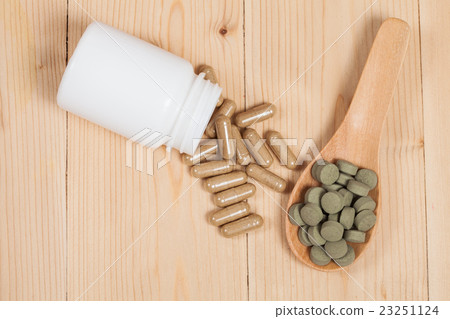 herb capsules spilling out of a bottle and pill herb capsules spilling out of a bottle and pill 23251124