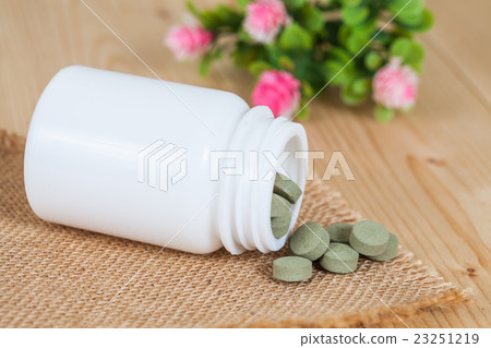 herb pill spilling out of a bottle herb pill spilling out of a bottle 23251219
