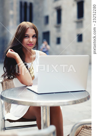 Tourist girl using her laptop in city 23252280