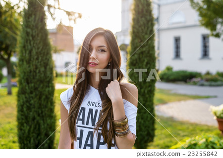Beautiful young brunette girl posing in a city Beautiful young brunette girl posing in a city 23255842