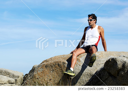 Sportsman listening to music in headphones Sportsman listening to music in headphones 23258383