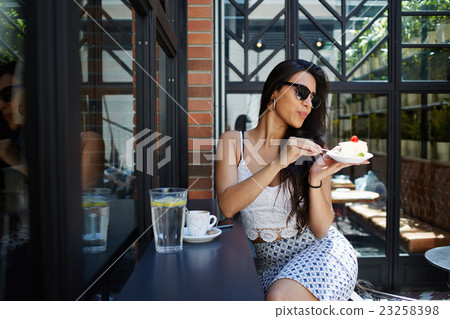 Wealthy female in sunglasses relaxing at cafe Wealthy female in sunglasses relaxing at cafe 23258398