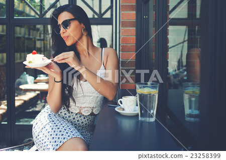 Female tourist eat sweet cake Female tourist eat sweet cake 23258399