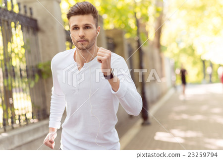 Skillful young jogger running outdoors 23259794
