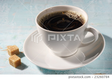 Cup of coffee in early morning sun rays Cup of coffee in early morning sun rays 23260784