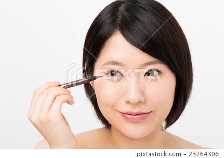 A woman drawing an eye line A woman drawing an eye line 23264306
