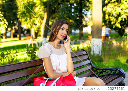 Beautiful girl sitting on a bench, brunette in Beautiful girl sitting on a bench, brunette in 23273261