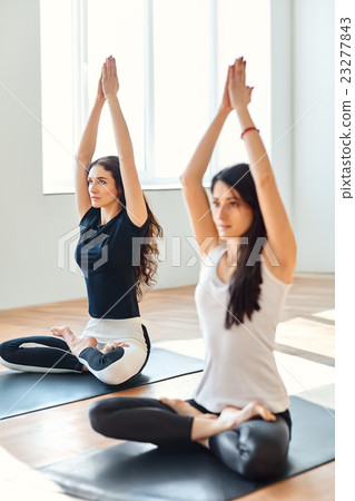 Two young women doing yoga asana Mountain Pose 23277843