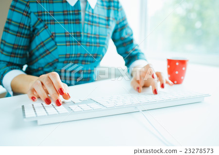 Woman office worker typing on the keyboard Woman office worker typing on the keyboard 23278573