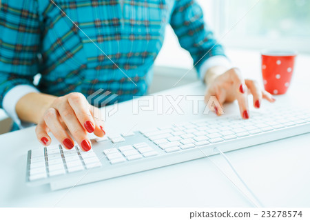 Woman office worker typing on the keyboard Woman office worker typing on the keyboard 23278574