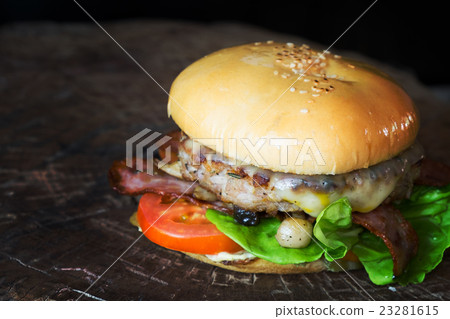 cheese burger on wood board over black background 23281615