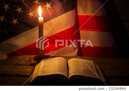 Burning candle and open book. 23284964