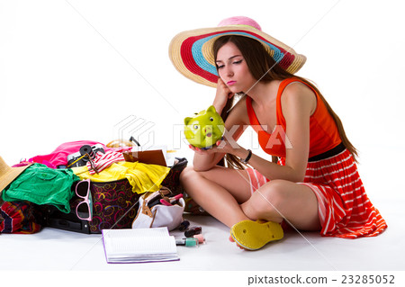 Girl sits near open suitcase. 23285052