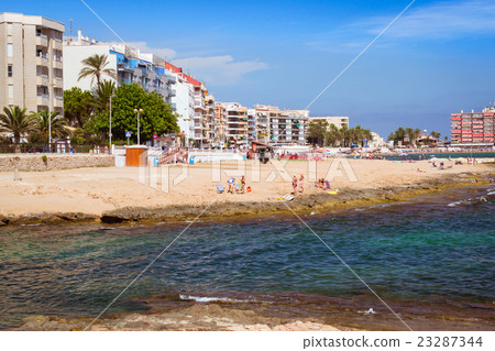 Sunny Mediterranean beach, Tourists relax on sand Sunny Mediterranean beach, Tourists relax on sand 23287344