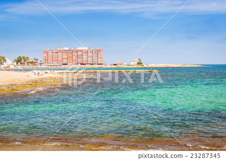 Sunny Mediterranean beach, Tourists relax on sand Sunny Mediterranean beach, Tourists relax on sand 23287345