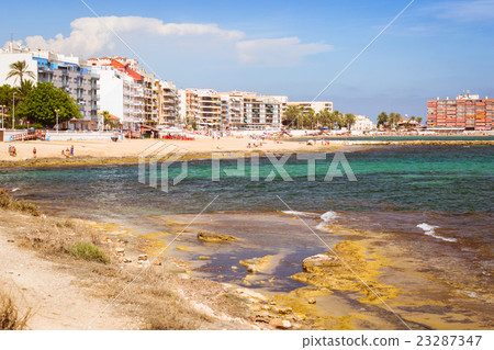 Sunny Mediterranean beach, Tourists relax on sand Sunny Mediterranean beach, Tourists relax on sand 23287347